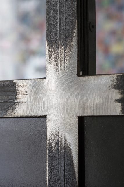 Détail d'une verrière en acier brut avec parties poncées (gris clair) et parties non poncées (gris foncé)